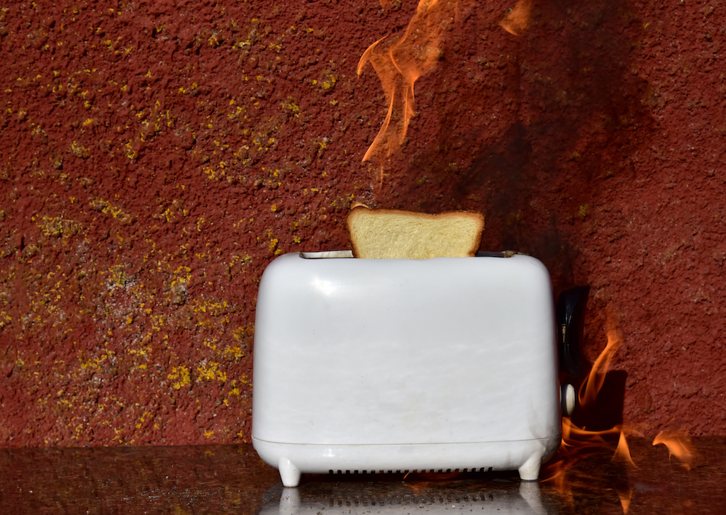 Toaster on fire in need of emergency electrician. 