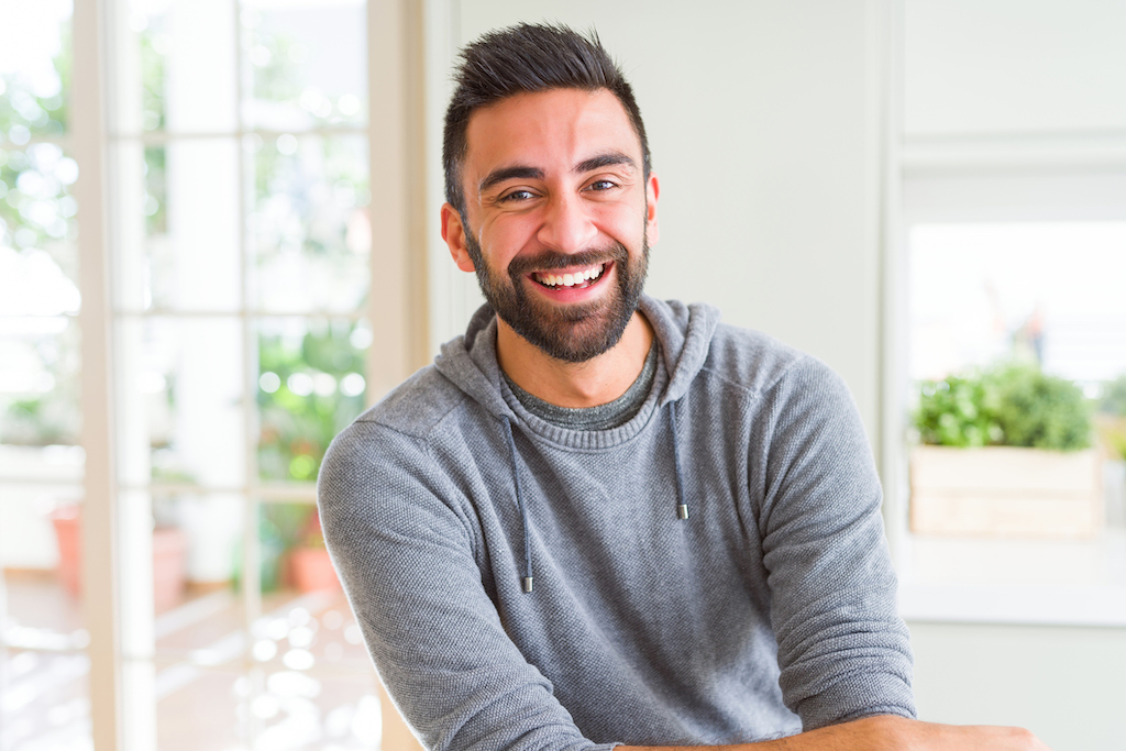 Man smiling in gray sweatshirt in home. | Emergency Electrical Repair
