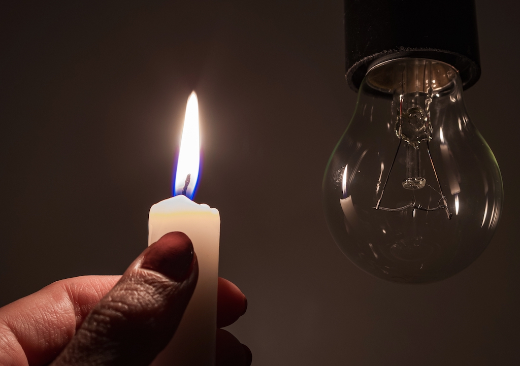 A lit candle next to a lightbulb during a power outage. | Generator